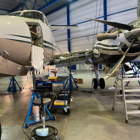 King Air B200 on jacks in the hangar with the left wing root opened up for the frame angle repair