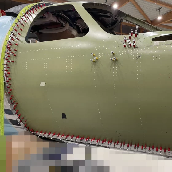 Replacement cockpit skin fitted and clecoed along the fastener rows